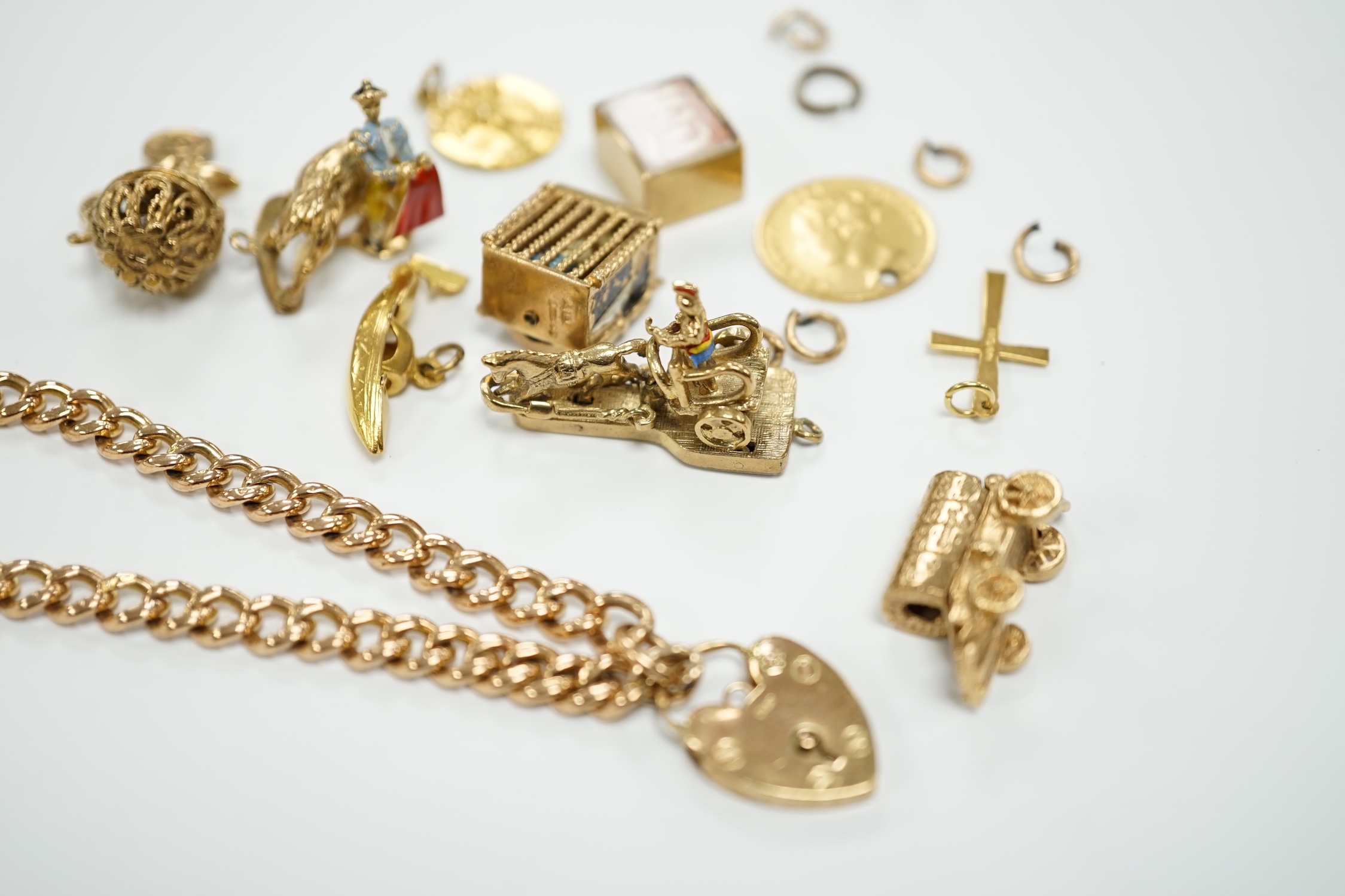 A 9ct gold curb link bracelet and eleven assorted mainly 9ct gold loose charms